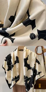 Close-up detail of vintage black and white floral silk scarf texture and elegant drape.