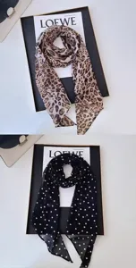 Detailed view of women's silk scarf, leopard and polka dot prints, elegant neck accessory.