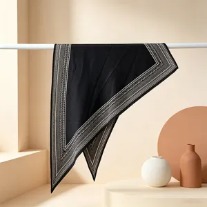 Elegant black triangular silk scarf with geometric border, perfect for summer chic fashion.