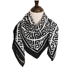 Foulard carré à imprimé géométrique noir et blanc sur mannequin, style rétro élégant.