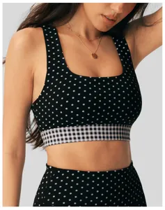 Zwarte en witte polkadot sport-bh met vierkante hals en stijlvolle geruite onderband.