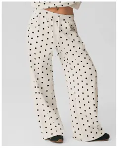Gedetailleerd overzicht van dameswijde broek met klassieke polkadotprint en trekkoord.