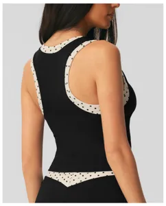 Detailweergave dames sportkleding met zwart-witte stippen fake tweestuks ontwerp achterzijde.