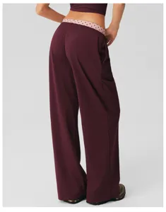 Gedetailleerd overzicht van de hoge taille wijde broek met contrasterende polkadottailleband.