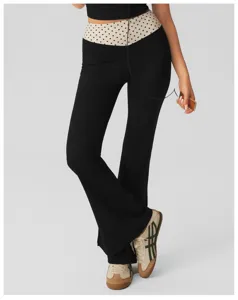 Detailed view of women's black flare yoga pants featuring a chic polka dot high waistband.