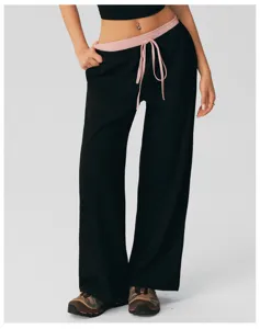 Gedetailleerd uitzicht van de zwarte casual sweatpants met hoge taille en polka dot tailleband.