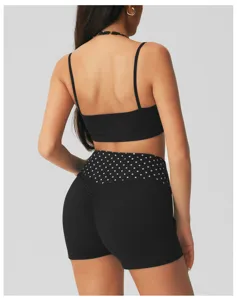 Gedetailleerd overzicht van zwarte yoga crop top en fitness korte broek met polkadots.