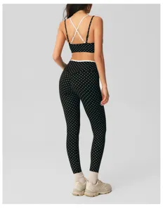 Detail view of black and white polka dot yoga set, featuring contrast cross straps and back design.