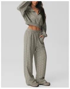 Grijs polkadot loungewear detail, met zip-crop top en hoge taille wijde pijpen broek.