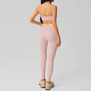Pink polka dot yoga set for women, featuring a cross-strap bra and high waist leggings.