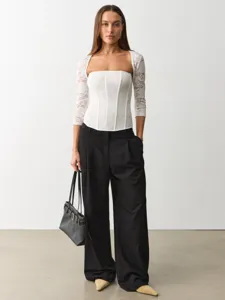 Women's elegant white lace square neck long sleeve top paired with stylish black wide leg trousers.