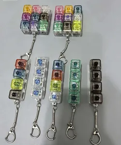 Detail view of transparent mechanical keyboard switch fidget toy keychains with metal rings.