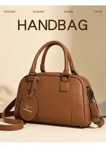 Brown leather boston handbag detail showcasing premium texture, sturdy handles and stylish design.