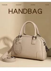 Elegant beige faux leather boston handbag with top handles and detachable shoulder strap.