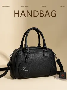 Black leather boston handbag with top handles and shoulder strap for women daily commute.