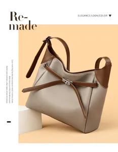 Detailed view of stylish two-tone shoulder bag featuring contrast belt and metallic turn-lock clasp.