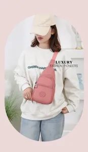 Detail shot of women casual nylon sling chest bag in pink, showing front zipper pocket design.