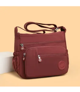Close-up detail of the wine red nylon multi-pocket shoulder bag, durable and lightweight design.