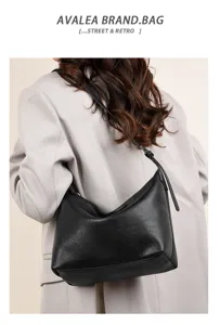 Detailed view of the stylish black shoulder dumpling bag showcasing soft leather texture and back wear.