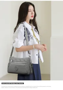 Detailed view of the grey nylon crossbody bag, showing multi-pocket design and strap.