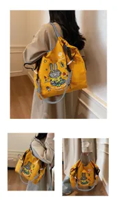 Cartoon canvas tote bag detail view showcasing cute rabbit embroidery and checkered straps.
