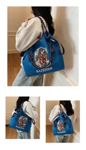 Large capacity blue canvas shoulder bag featuring stylish lion embroidery and comfortable strap.