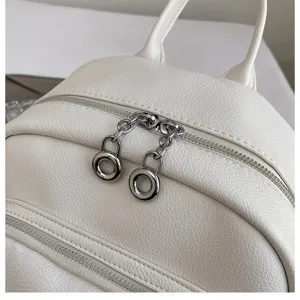 Closeup detail of white faux leather casual backpack zipper with silver ring pullers.