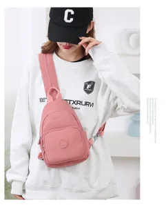 Vista dettagliata della borsa a tracolla rosa in nylon elegante indossata dalla modella.