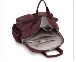Dettaglio zaino in nylon che mostra scomparti interni e tasche con cerniera.