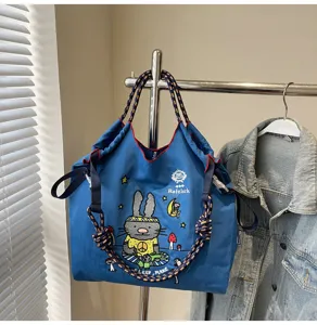Casual large capacity blue canvas tote bag with cute cartoon embroidery and rope handles.