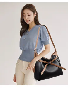 Close-up detail of the black and brown soft leather shoulder bag worn by model.