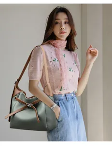 Detailed view of stylish women soft leather shoulder bag with brown strap and metal lock closure.