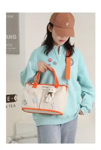 Large capacity canvas diaper bag tote with handles and shoulder strap for mothers and travel.
