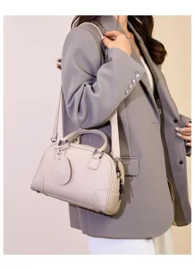 Close-up detail of stylish women's leather Boston shoulder bag in elegant light grey color.