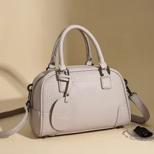 Classic women solid color leather boston handbag with top handle and adjustable strap.