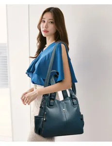 Detailed view of women's stylish leather shoulder bag worn by model in elegant studio setting.