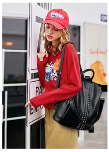 Black PU leather women backpack with stylish rivet decoration and versatile daily use.