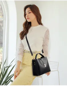 Stylish women's black leather bucket bag with metal lock design, ideal for daily use.