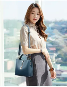 Detailed view of dark blue soft leather bucket bag worn by model, shoulder strap design.