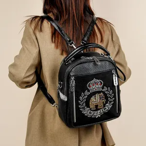 Stylish black leather backpack for women with rhinestone crown elephant crest and straps.