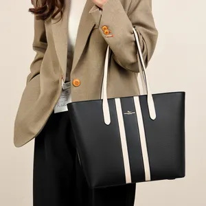 Women black PU leather tote bag large capacity commuter shoulder handbag with white contrast stripes.