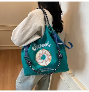 Detail view of Japanese embroidered nylon casual shoulder tote bag with donut graphic.