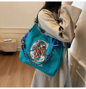 Green canvas tote bag with geometric lion embroidery and thick braided strap for daily commute.