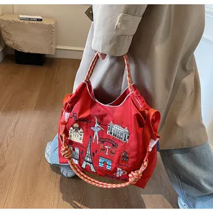 Detail shot of the red nylon shoulder bag featuring intricate Paris embroidery and rope handles.