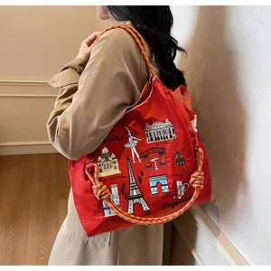 Red nylon canvas shoulder bag with Paris landmark embroidery and unique rope handles.