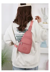 Detailed view of the pink nylon chest bag showing zipper pocket, adjustable strap and back wear.