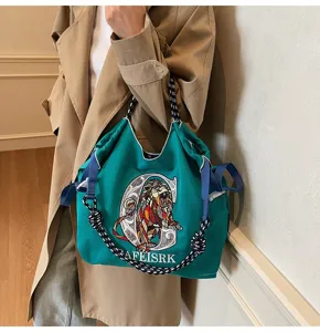 Embroidered canvas tote bag with lion graphic and shoulder strap for women commuter use.