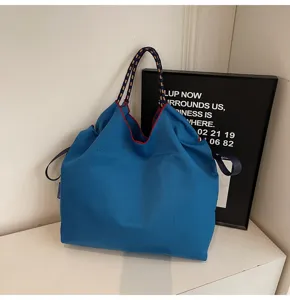 Large capacity blue canvas tote bag with rope handles and red trim detail for casual daily use.