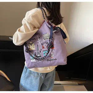 Detailed view of the purple canvas shoulder bag featuring stylish Paris embroidery patterns.