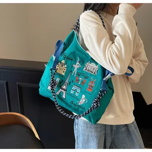 Detailed view of the green embroidered shoulder bag showcasing Paris landmarks and rope straps.